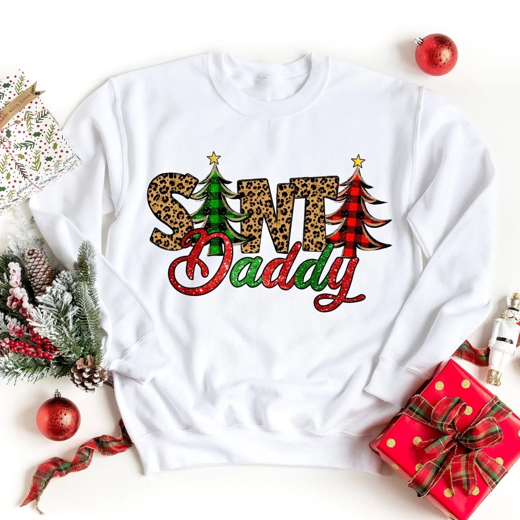 White crewneck sweatshirt with colorful 'Santa Daddy' graphic and Christmas trees