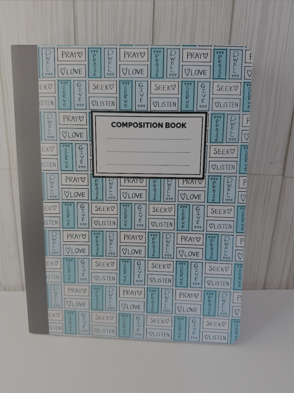 Blue composition book with prayer-themed typographic cover and ruled writing lines
