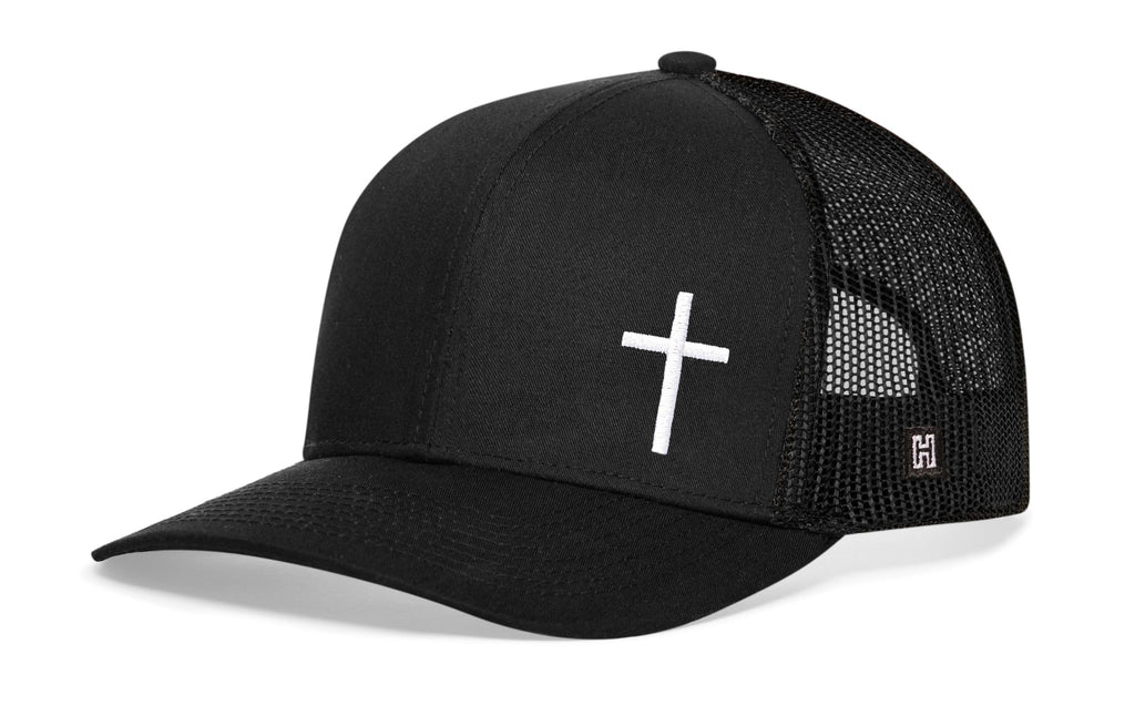 Black trucker snapback cap with white cross on front, mesh sides, snapback.