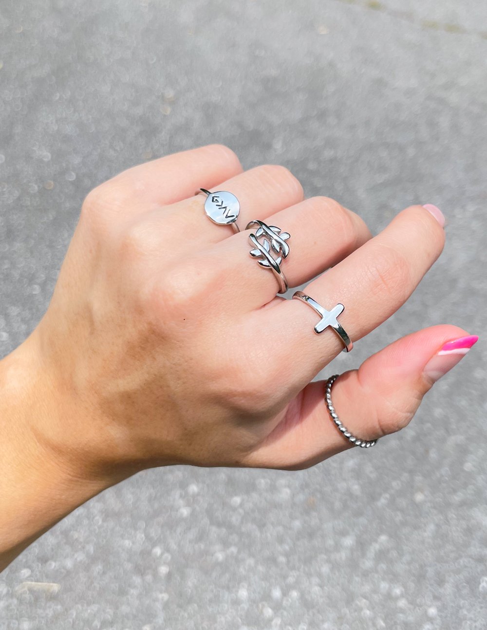 Silver cross ring with small cross emblem on finger