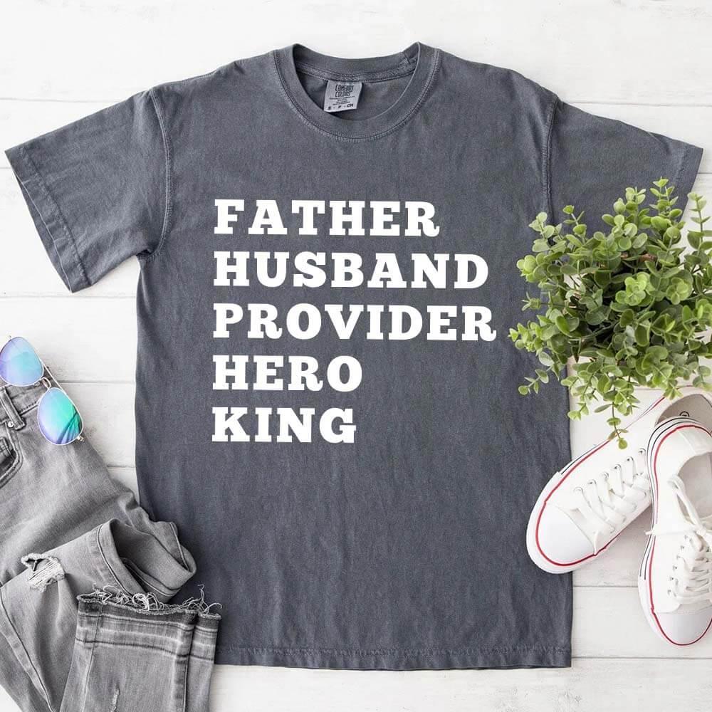 Charcoal gray crewneck T-shirt with stacked "FATHER HUSBAND PROVIDER HERO KING" print