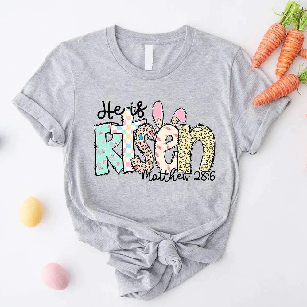 Heather gray T-shirt with colorful Easter graphic 'He is Risen' and 'Matthew 28:6'.
