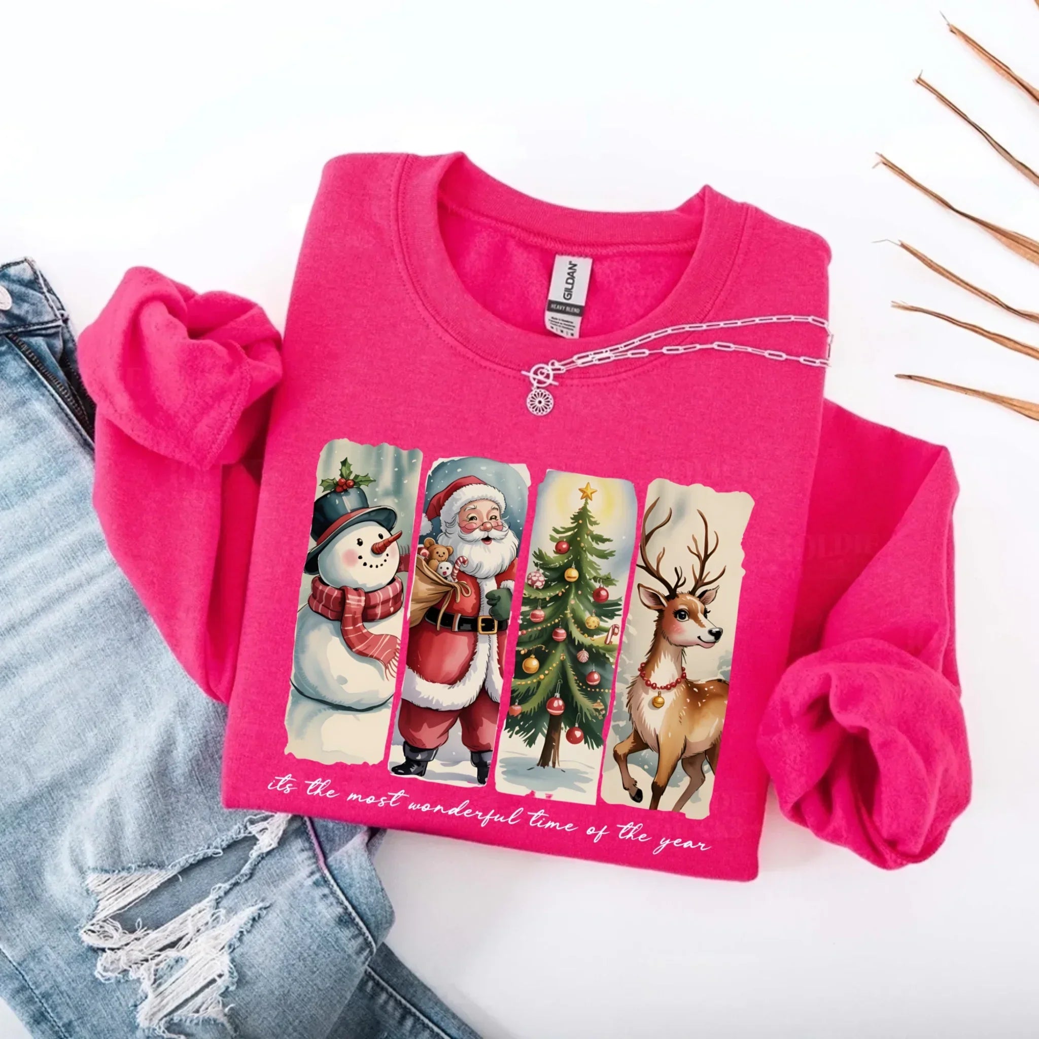 Pink crewneck sweatshirt with Santa, snowman, and reindeer graphic on front