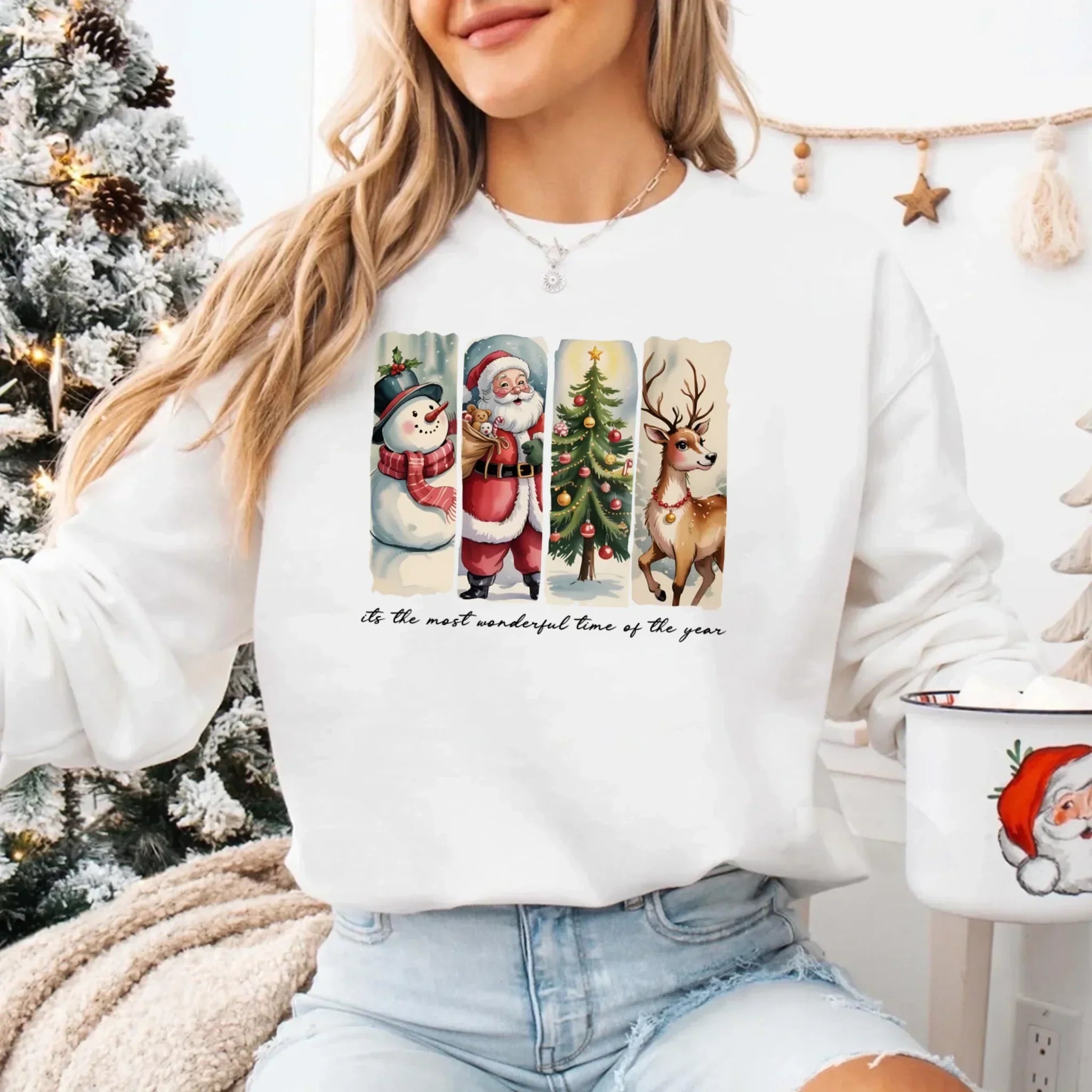 White crewneck sweatshirt with Santa, snowman, tree, and reindeer graphic on front