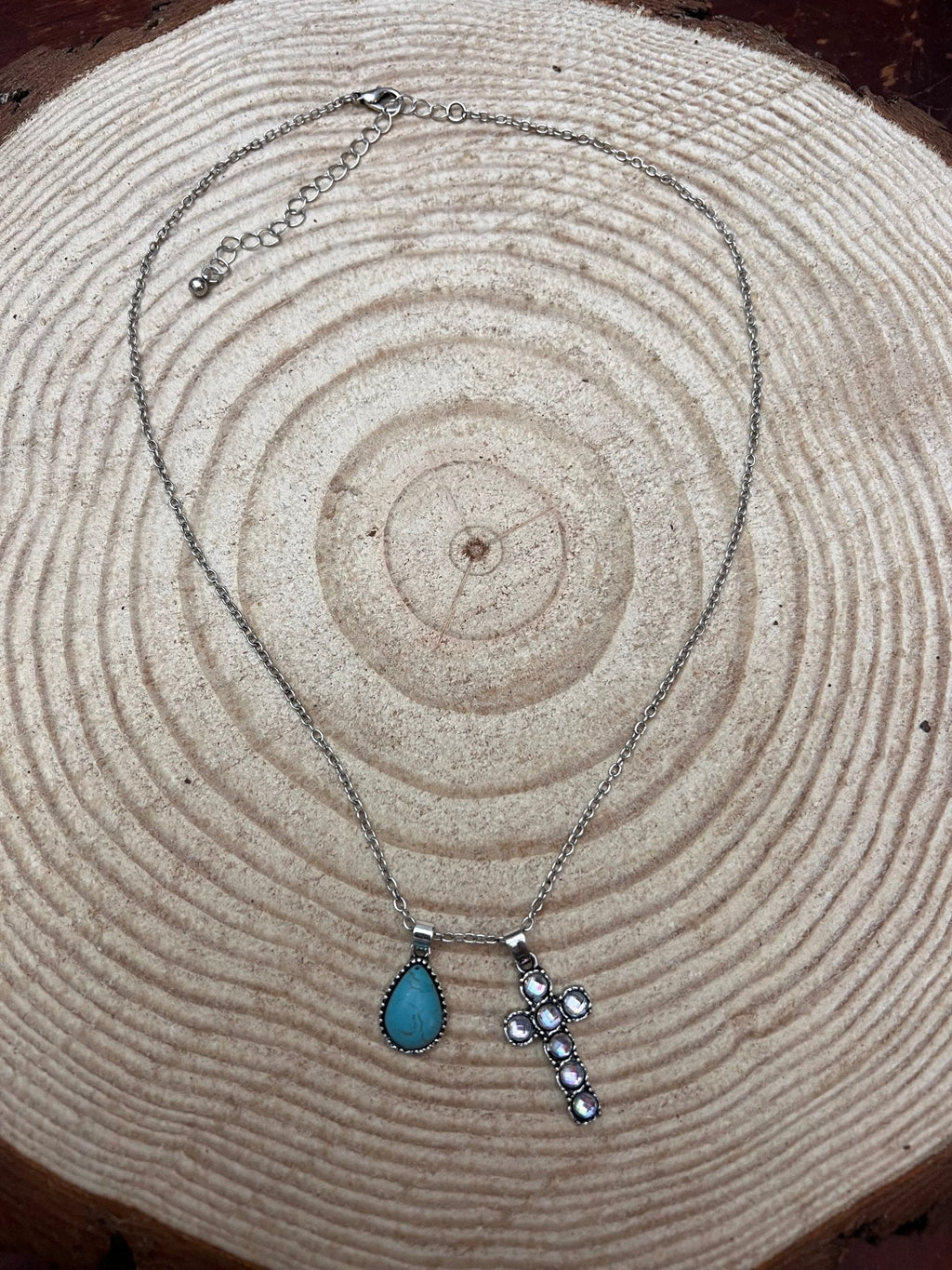 Turquoise teardrop cross dangle necklace with silver chain, side view