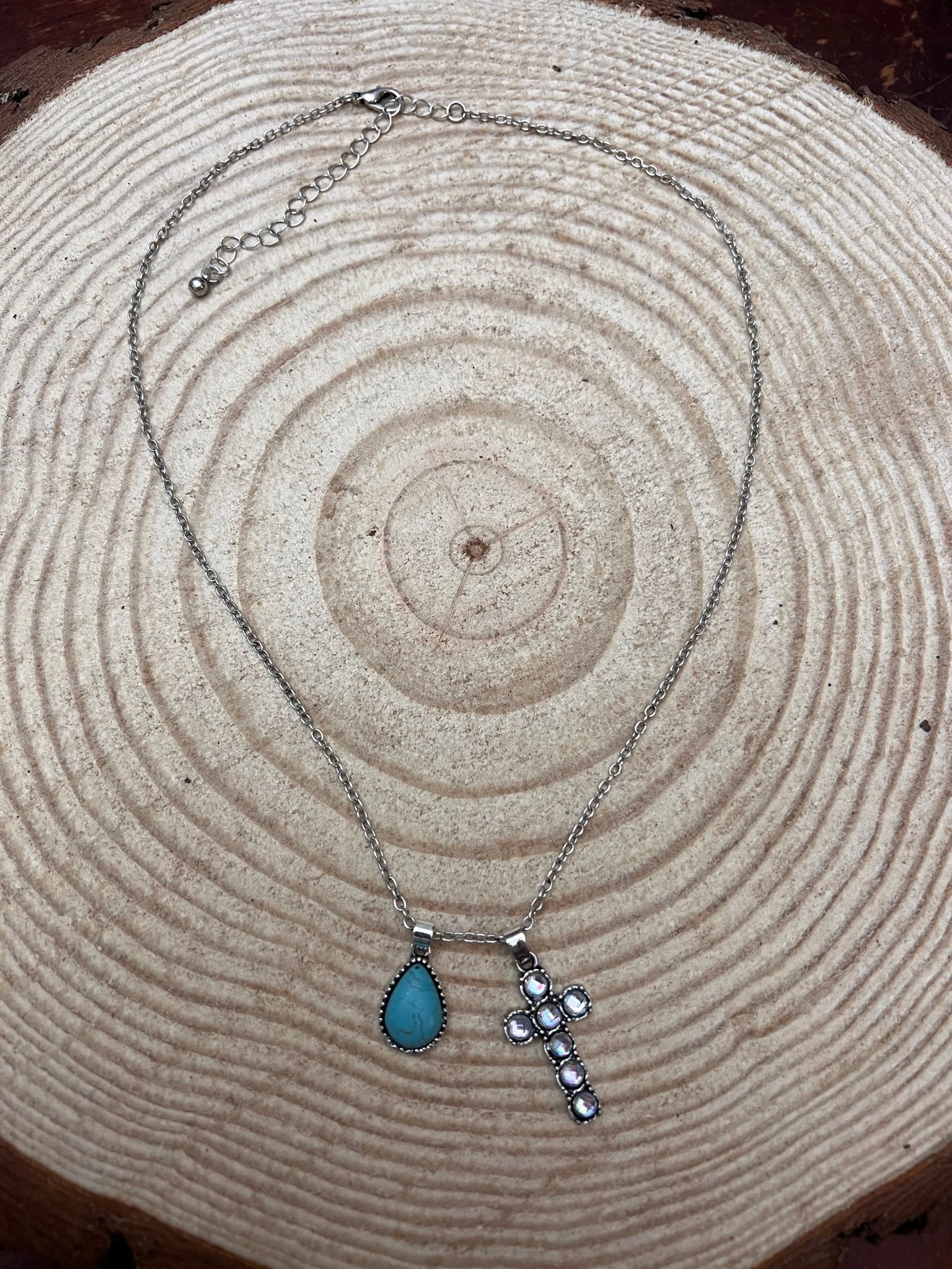 Turquoise teardrop cross dangle necklace with silver chain, side view