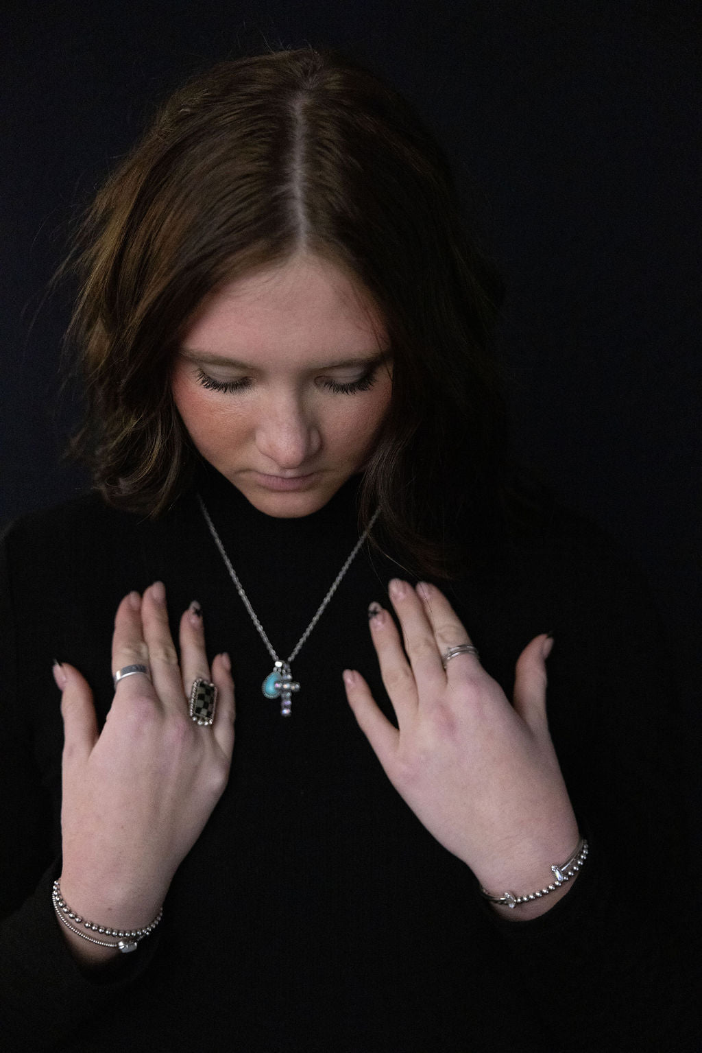 Turquoise teardrop cross necklace with silver chain worn, rhinestone details visible