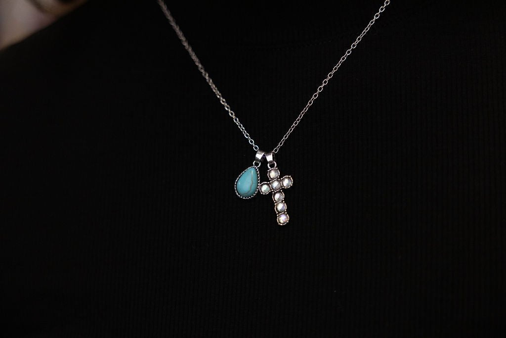 Turquoise teardrop and rhinestone cross necklace with silver chain, close view