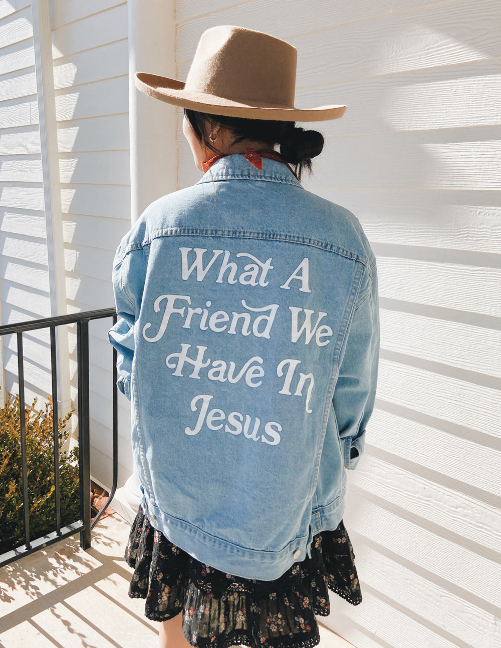 Light-wash denim jacket with large back graphic text and button front