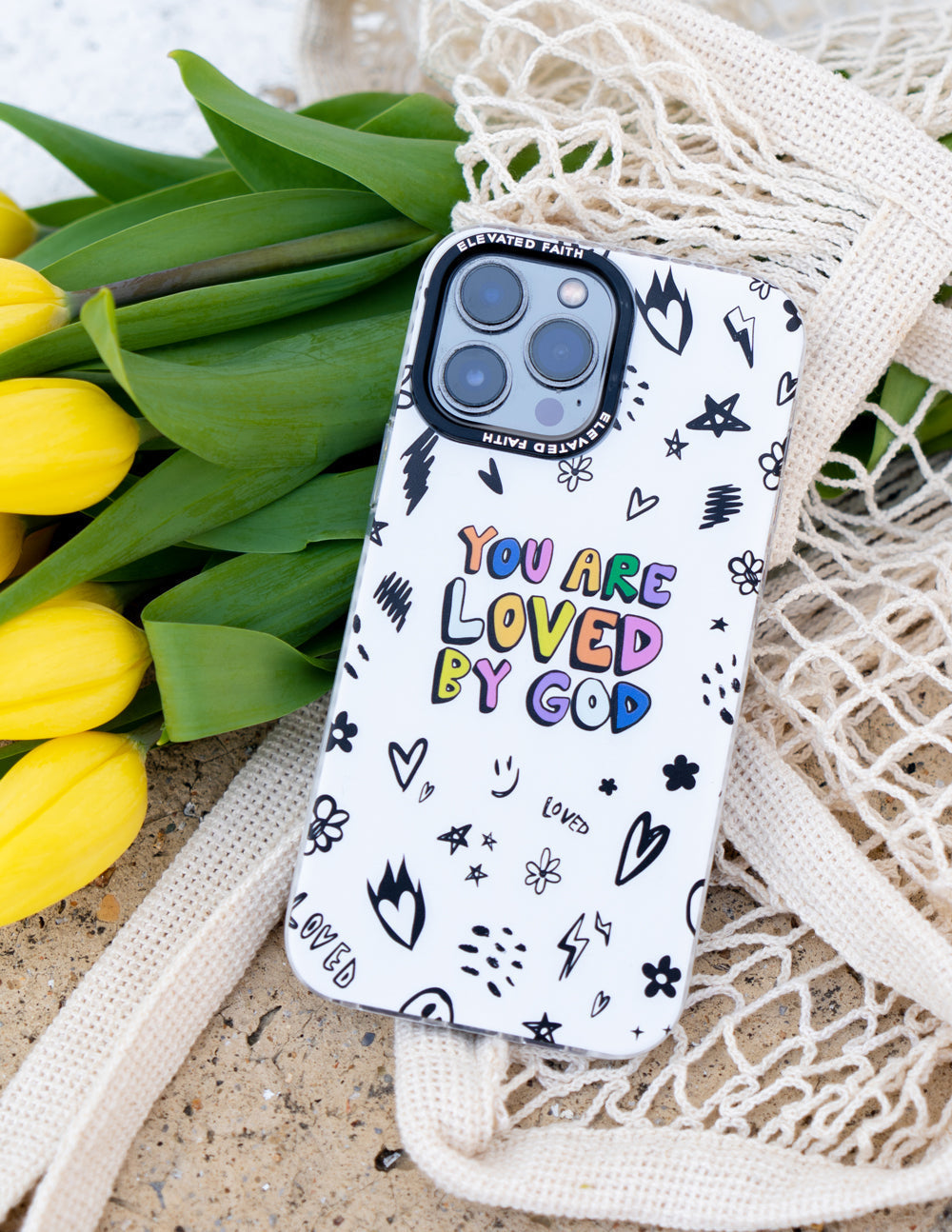 White phone case with 'You are loved by God' lettering, hearts and star pattern