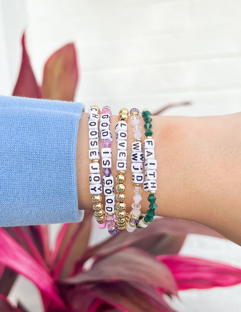 WWJD letter bracelet stack with multicolor beads, gold accents, and letter blocks