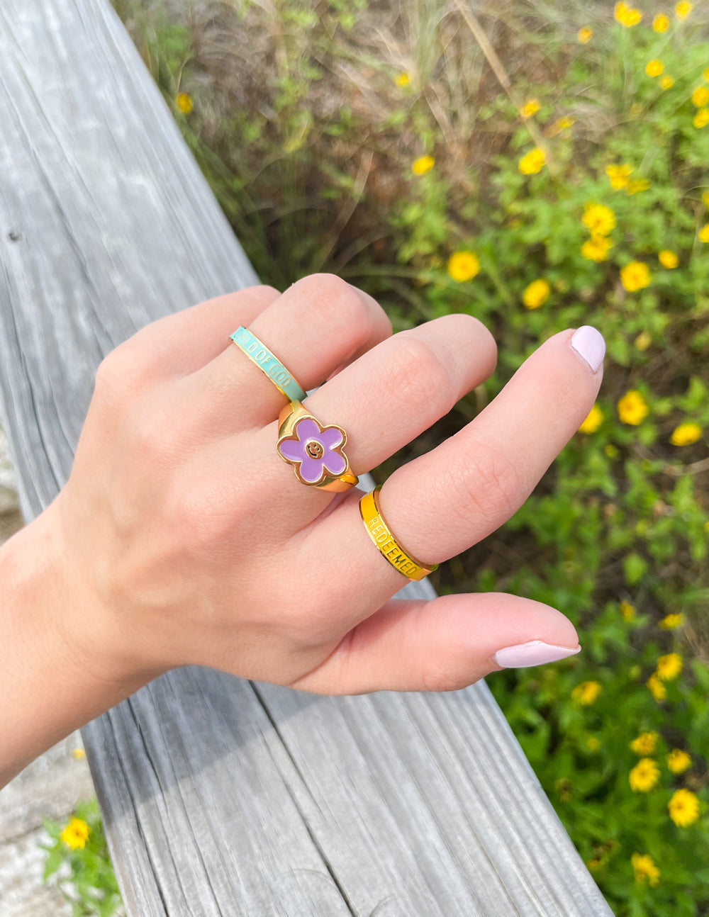 Yellow enamel ring with REDEEMED text and small purple flower charm