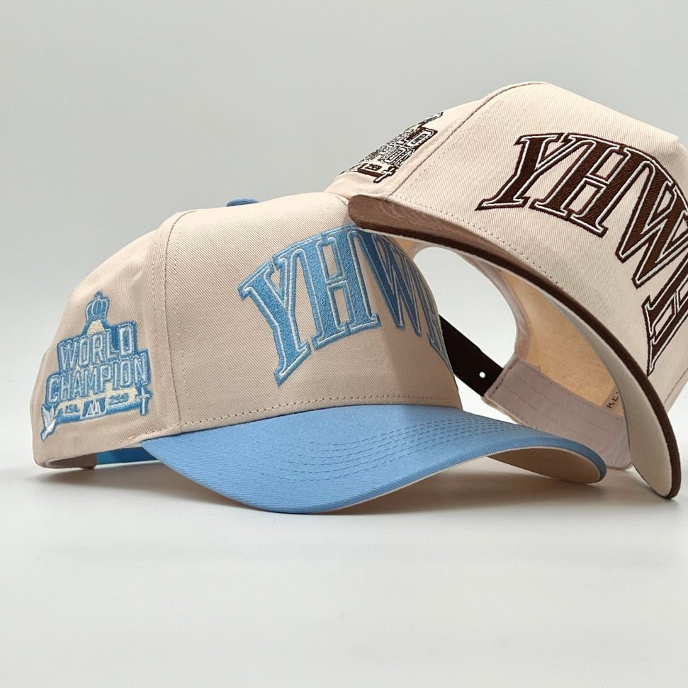 Cream and baby blue snapback cap with YHWH front logo and curved blue brim