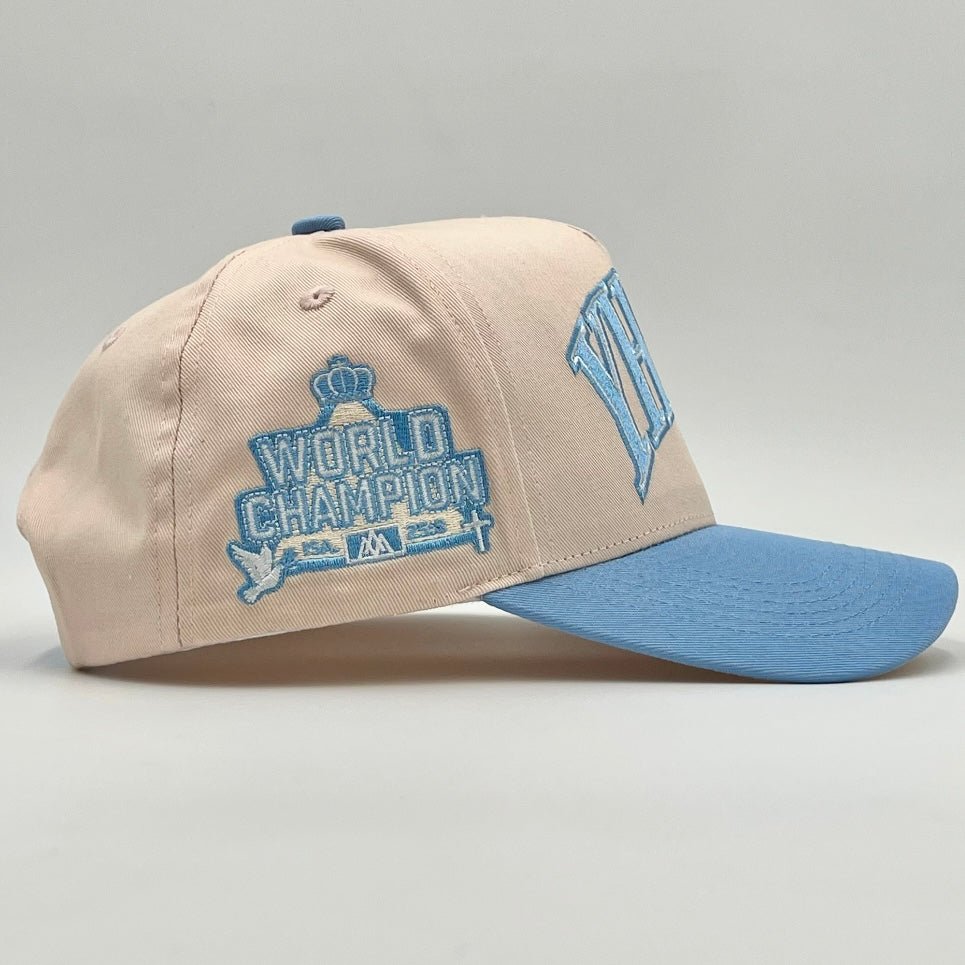 Cream and baby blue snapback cap with World Champion logo on side panel