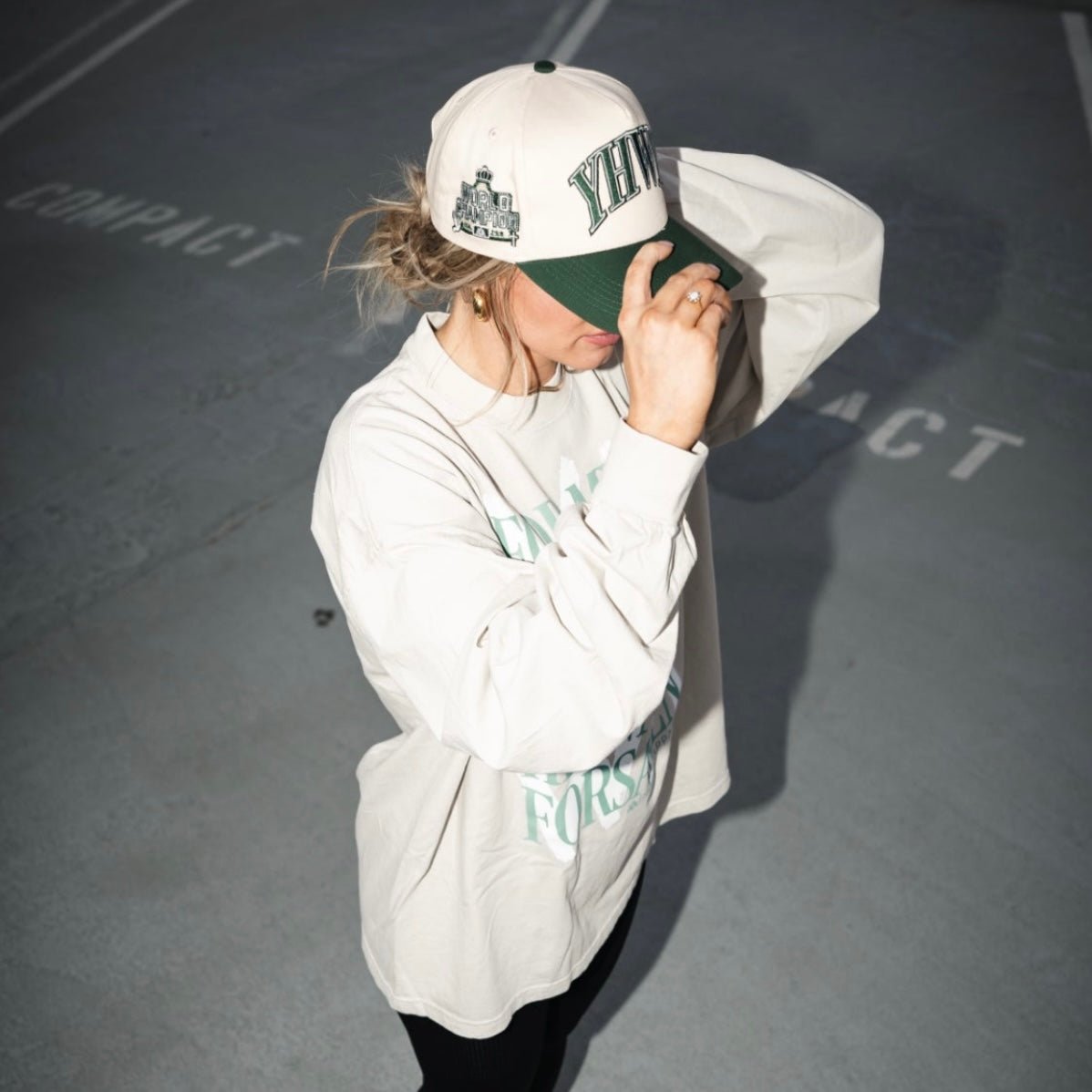 Cream and green snapback cap with YHWH logo, worn